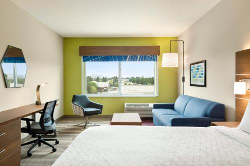 a hotel room with a bed and a desk and a couch at Holiday Inn Express & Suites - Ukiah by IHG in Ukiah