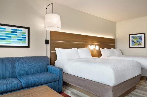 a hotel room with two beds and a blue chair at Holiday Inn Express & Suites - Ukiah by IHG in Ukiah