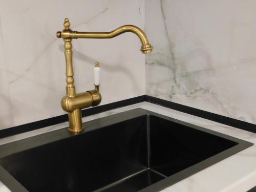 a black sink with a brass faucet at Brand New Studio 1 in Komotini