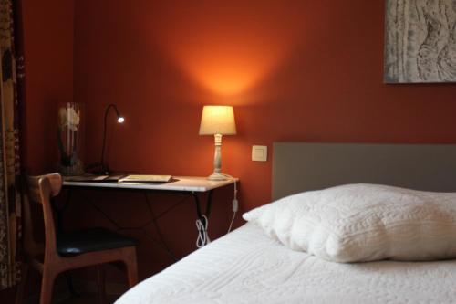 a bedroom with a bed and a desk with a lamp at Green Hill Guest House and Apartment in Overijse
