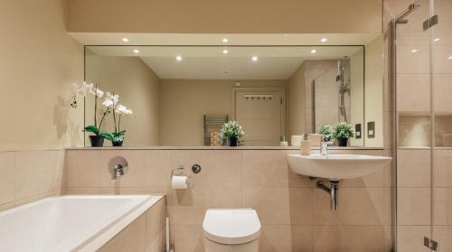 une salle de bain avec un lavabo, des toilettes et un miroir dans l'établissement Willow Cottage at Gravel Farm, à Stretham
