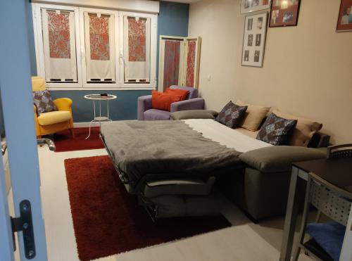 een slaapkamer met een bed en een bank en stoelen bij Apartamento Gallarza !!! PARKING PRIVADO GRATUITO!! in Logroño