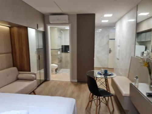 um quarto com um sofá, uma mesa e uma casa de banho em Aparthotel BSB Flats em Brasília