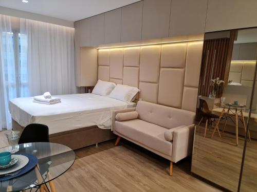 a bedroom with a bed and a chair and a table at Aparthotel BSB Flats in Brasilia