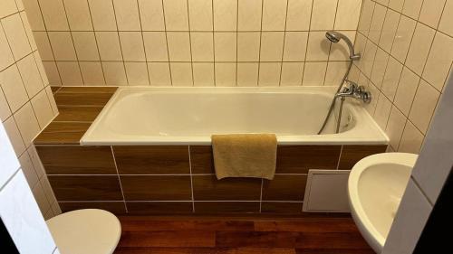 a bathroom with a tub and a toilet and a sink at Pension Plestil in Liberec