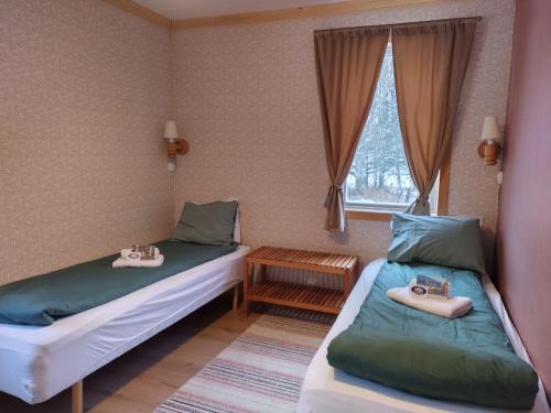 twee bedden in een kleine kamer met een raam bij Hammarstrand Budget Hotell- Lergodset in Hammarstrand