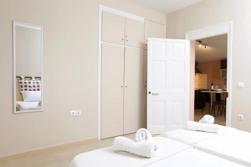 1 dormitorio con 2 camas blancas y espejo en Casa Di Nina, en Ýpsos