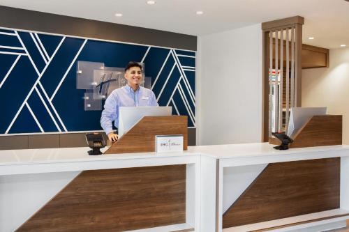 a man standing at a desk with a laptop at Holiday Inn Express & Suites - Ukiah by IHG in Ukiah
