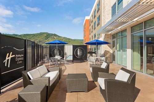 un patio con sillas, mesas y sombrillas en un edificio en Holiday Inn Express & Suites - Ukiah, an IHG Hotel, en Ukiah