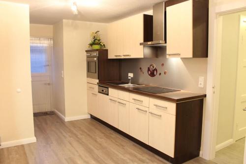 a kitchen with white cabinets and a counter top at Haus-Luise in Poppenbüll