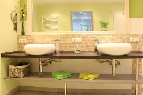 ein Badezimmer mit 2 Waschbecken und einem Spiegel in der Unterkunft Haus Luise in Poppenbüll