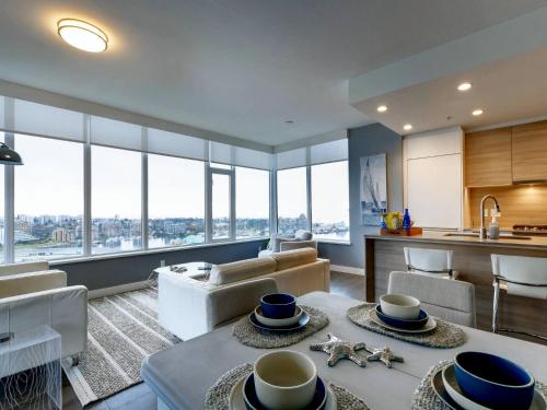 a kitchen and living room with views of the city at Admiral's Anchor by IRIS PROPERTIES! in Victoria