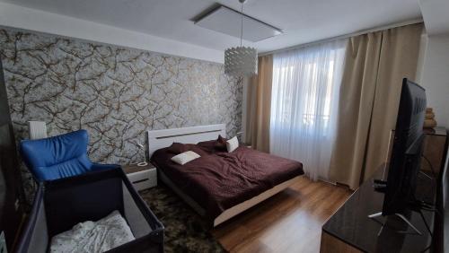 a bedroom with a bed and a blue chair at Apartment Panorama 35C in Donovaly