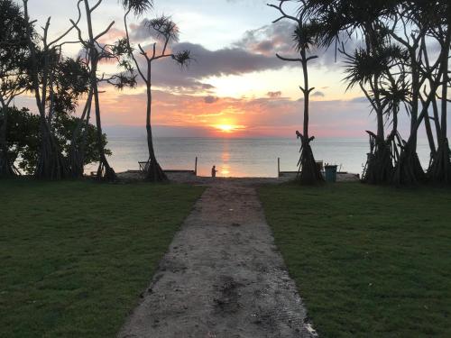 un chemin menant à la plage au coucher du soleil dans l'établissement Walden Koh Lanta - Tiny Homes by the Sea, à Ko Lanta
