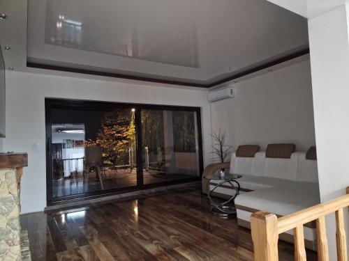 a living room with a large window and a table at Vila Odiseas in Belgrade