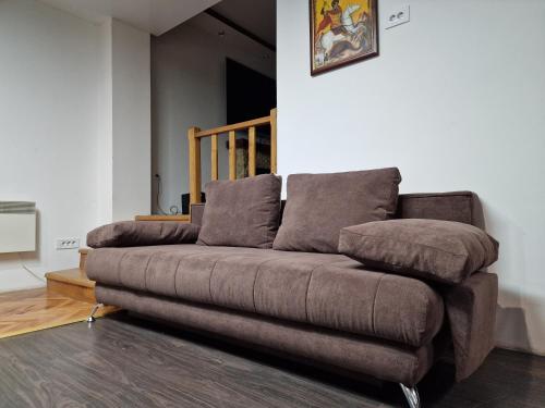 a brown couch sitting in a living room at Vila Odiseas in Belgrade