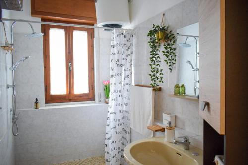 a bathroom with a sink and a shower curtain at La Casa del Carrubo in Cagliari