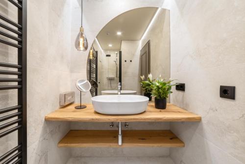 a bathroom with a sink and a mirror at Boutique Hotel ANYBODY in Saalbach Hinterglemm