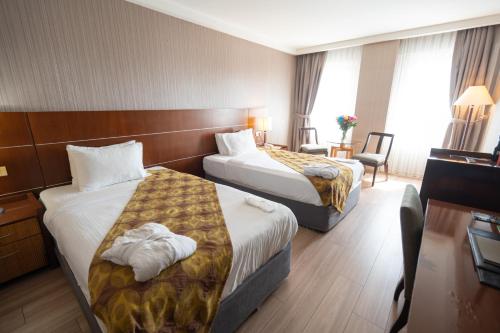 a hotel room with two beds and a desk at The Green Park Bostancı in Istanbul