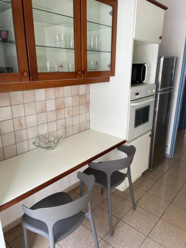 uma cozinha com um balcão, 2 cadeiras e um frigorífico em Appartement Cosy Pointe-à-Pitre em Pointe-à-Pitre