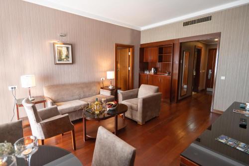 a living room with a couch and chairs and a table at The Green Park Bostancı in Istanbul