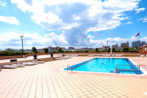 a large swimming pool with lounge chairs and a sky at The Green Park Bostancı in Istanbul