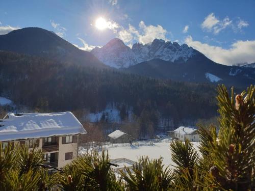 a view of a snow covered mountain range with a building at Alessandra in Fusine in Valromana