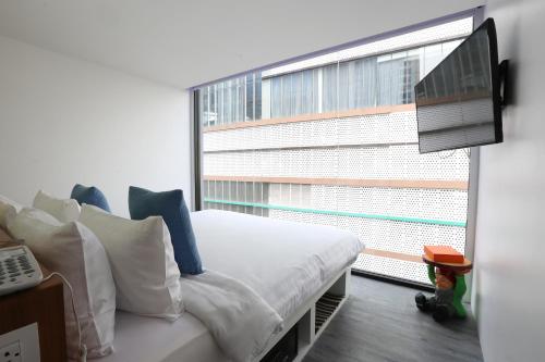 a bedroom with a bed and a large window at S Box Sukhumvit Hotel - SHA Extra Plus in Bangkok