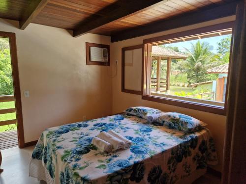 een slaapkamer met een bed en een raam bij Paraíso Verde Arraial d'Ajuda PNM01 in Porto Seguro