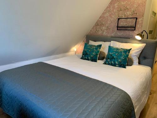 a bedroom with a large bed with blue sheets and pillows at B&B bij Vincent in Nieuw-Amsterdam