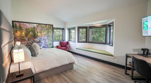a bedroom with a bed and a desk and windows at Icon Inn in Ellensburg