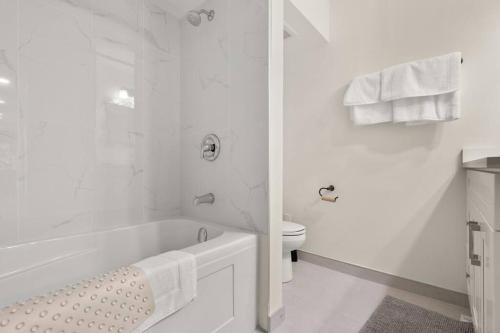 bagno bianco con vasca e servizi igienici di Skytrain 2BR Reno'd ground level fullsuite near Coquitlam Center a Port Coquitlam