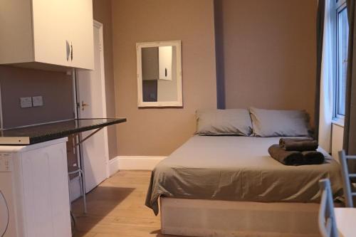 a small bedroom with a bed and a kitchen at Studio on Finchley Road in London