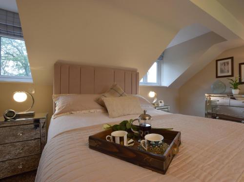 um quarto com uma cama com uma bandeja com duas canecas em Solway em Chester
