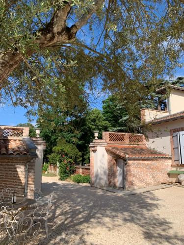 a brick building with a gate and a tree at Chambre d'hotes et Table d'hotes Domaine de la terrasse SAS et Gite ANDA Montauban in Lacourt-Saint-Pierre