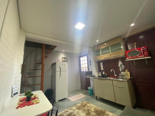 eine Küche mit einem Kühlschrank und einem Tisch darin in der Unterkunft Moradas Desterro, próximo ao aeroporto 06 in Florianópolis