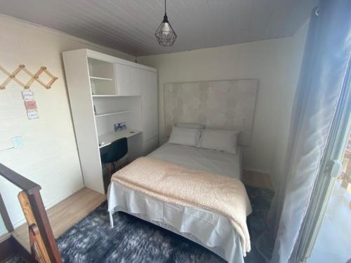 um pequeno quarto com uma cama e uma secretária em Moradas Desterro, próximo ao aeroporto 06 em Florianópolis