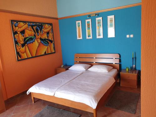 a bedroom with a bed with a blue wall at Villa Frida in Sveti Stefan