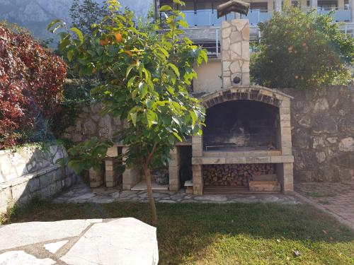 a stone fireplace in a yard with a tree at Villa Frida in Sveti Stefan