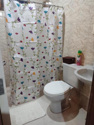 baño con aseo y cortina de ducha con mariposas en Mangue House 2 en Barra de Guaratiba