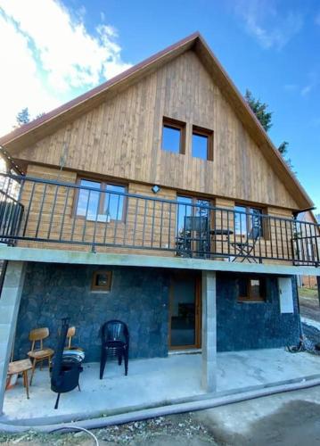 a house with a balcony on top of it at Chata TRI GROŠE 1 in Námestovo