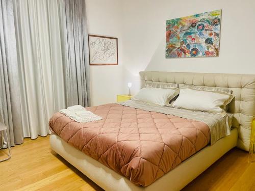 una camera da letto con un letto con sopra un dipinto di Casa Florenzia a Porto San Giorgio