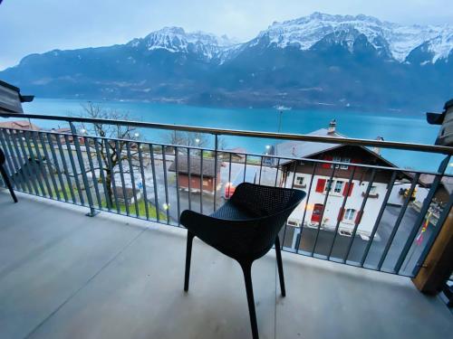 a chair on a balcony with a view of the mountains at Lake View Residence in Niederried