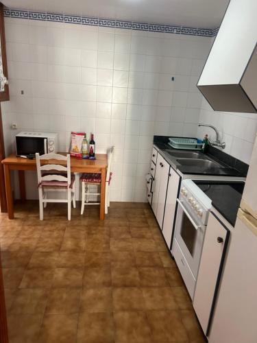 a kitchen with a table and a stove top oven at BRESSOL DELUXE Apartments in Port de Pollensa