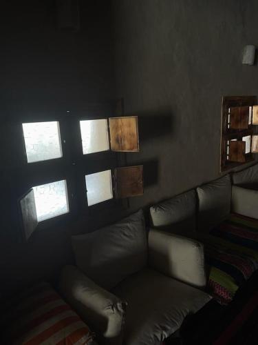 a living room with a leather couch and windows at Siwa Desert Home in ‘Izbat Ţanāţī