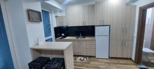 - une cuisine avec des placards en bois et un réfrigérateur blanc dans l'établissement Mavrov02 Residence, à Mavrovo