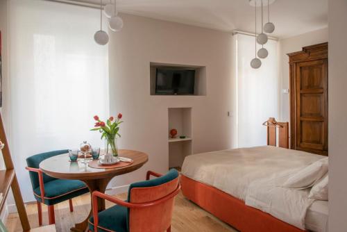 a bedroom with a bed and a table and chairs at una stanza in carmine in Brescia