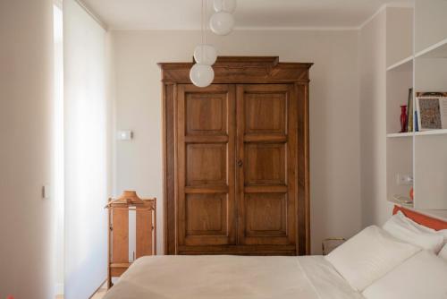 a bedroom with a wooden cabinet and a bed at una stanza in carmine in Brescia