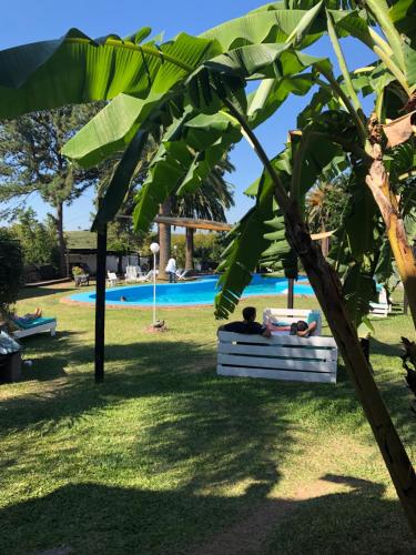 a couple sitting in a hammock under a tree near a pool at La Posada del Minero in Minas de Corrales