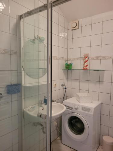 a bathroom with a washing machine and a sink at Inselzauber in Breege